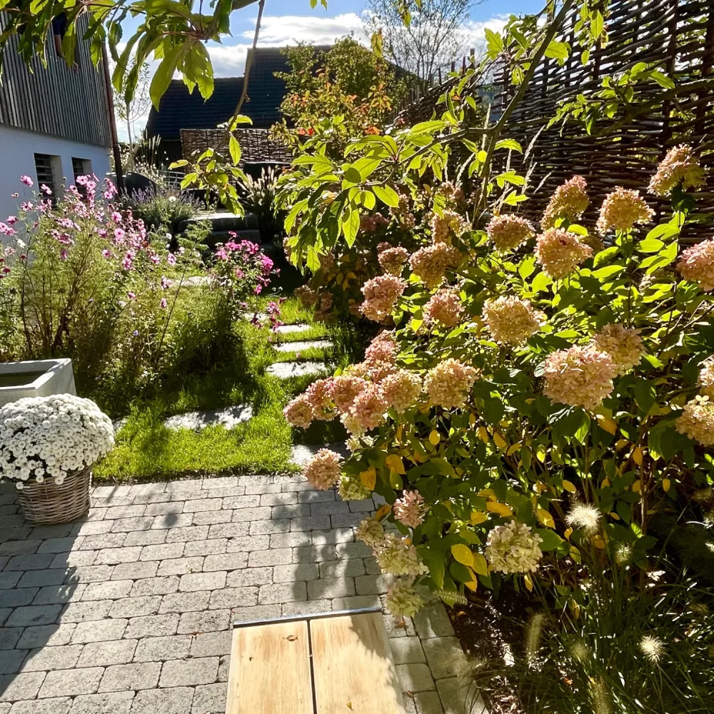 ein Garten mit viel Grün und einem Steinboden